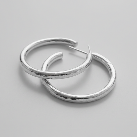 Pair of silver hoop earrings on a gray background
