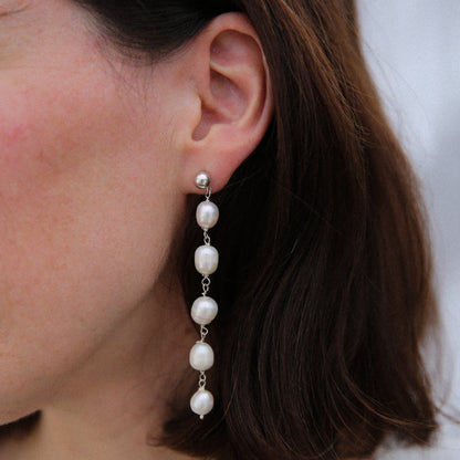 Pearl earring worn by a person with a neutral background