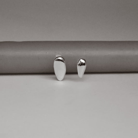 Pair of silver earrings on a gray background