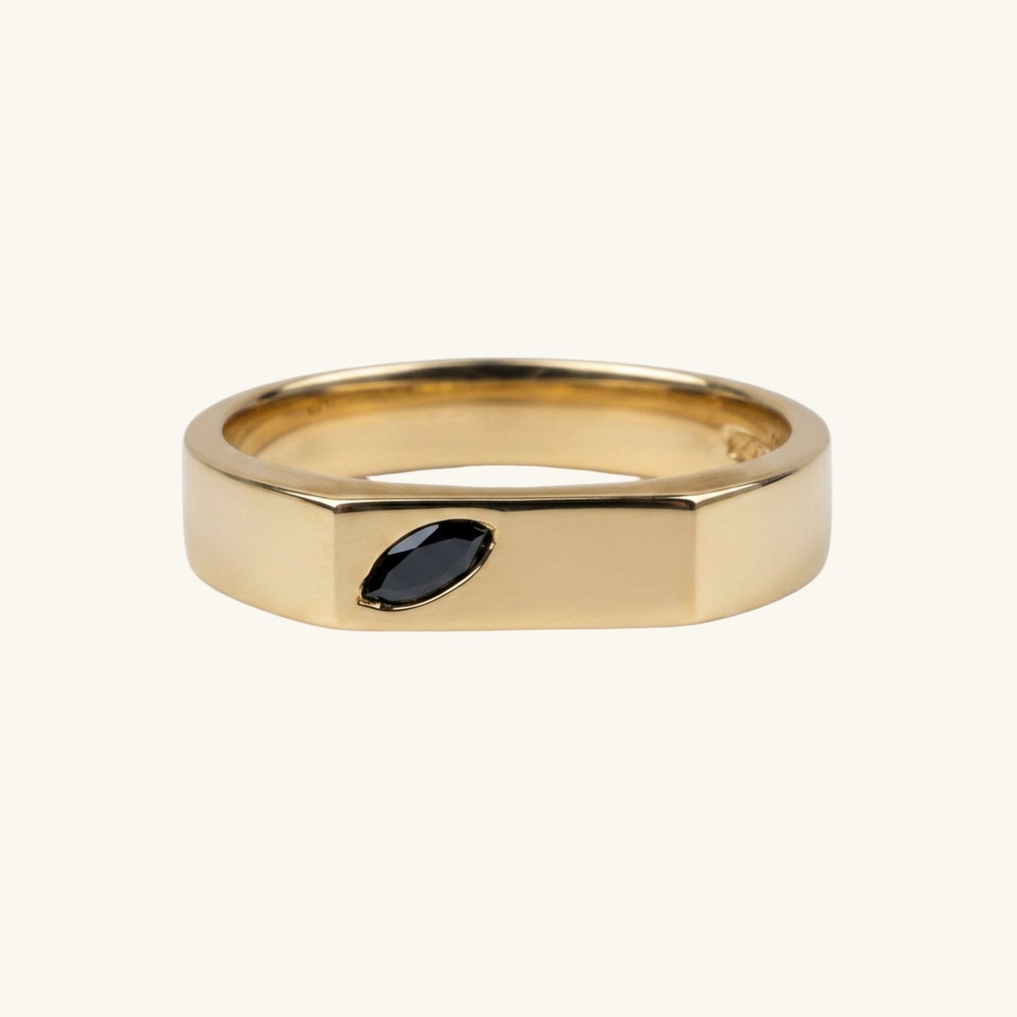 Gold ring with a marquise gemstone on a white background