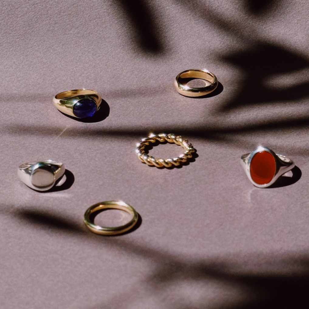a collection of gold and silver rings on a shadowy grey coloured background