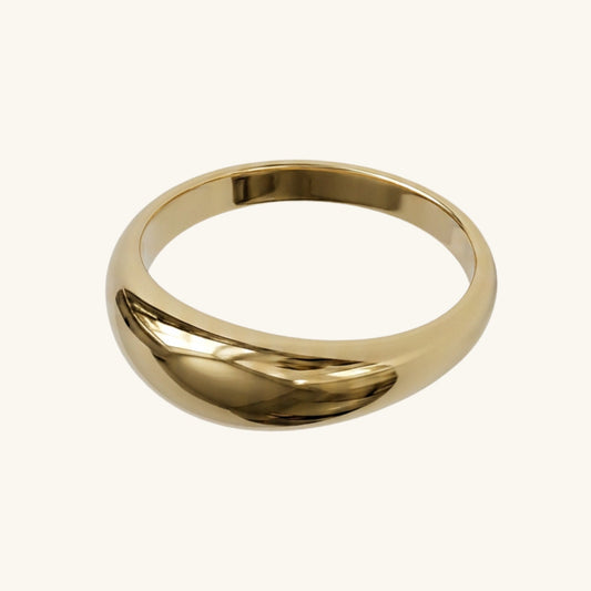 Gold ring on a cream background