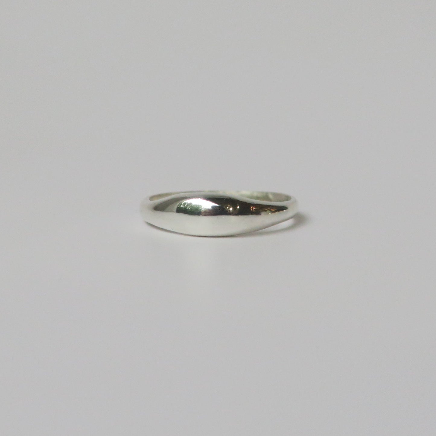 Silver ring on a light gray background