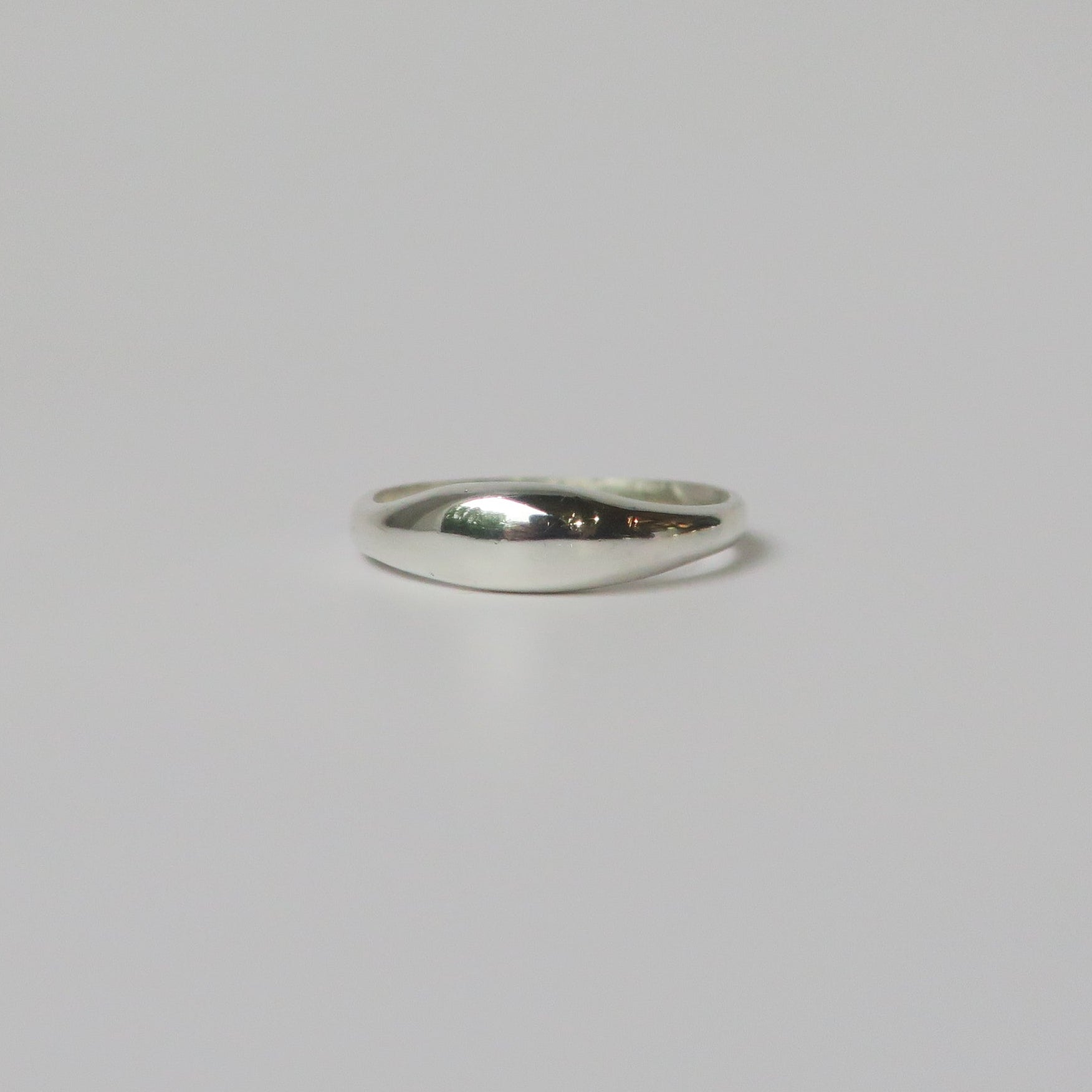 Silver ring on a light gray background