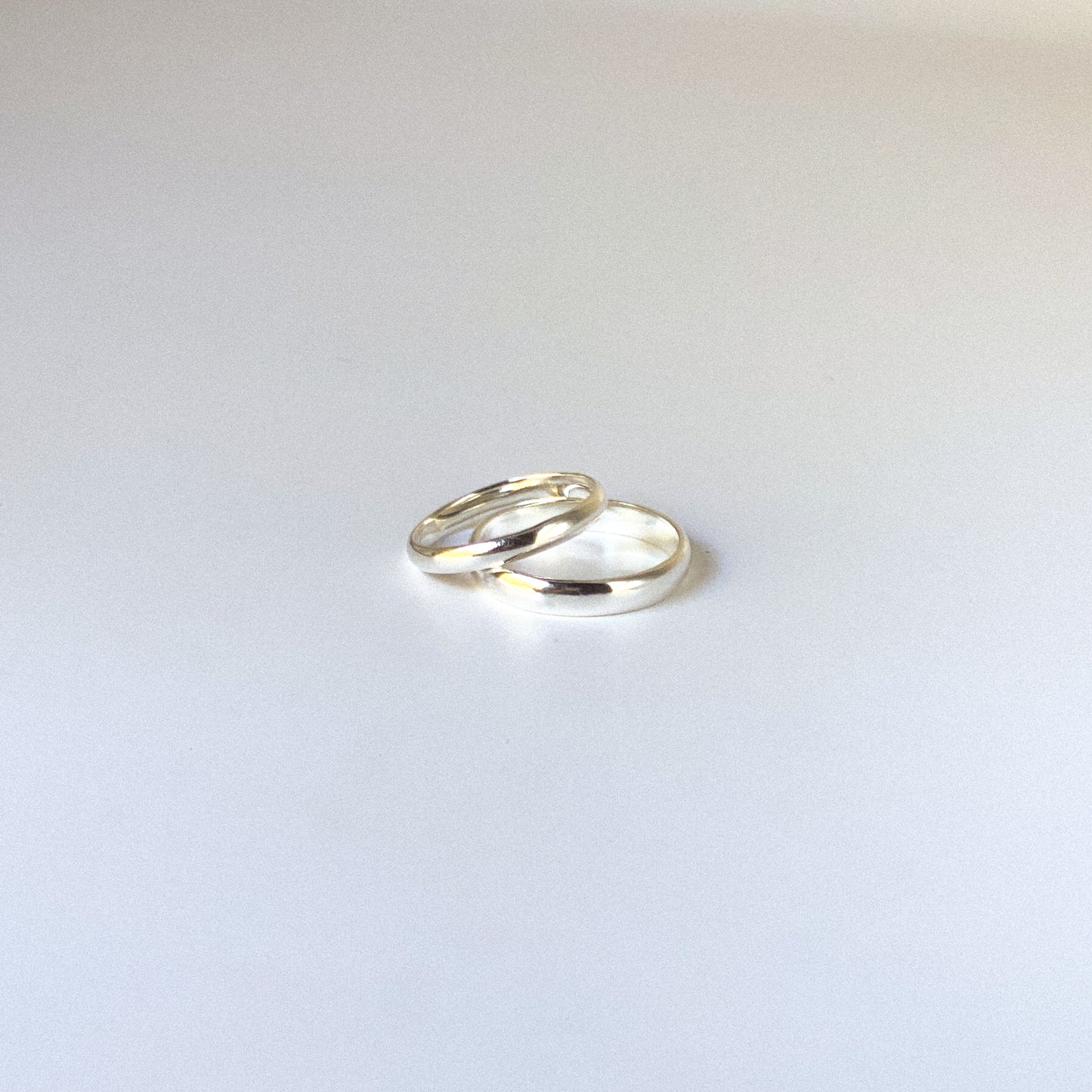 Two silver rings on a light gray background