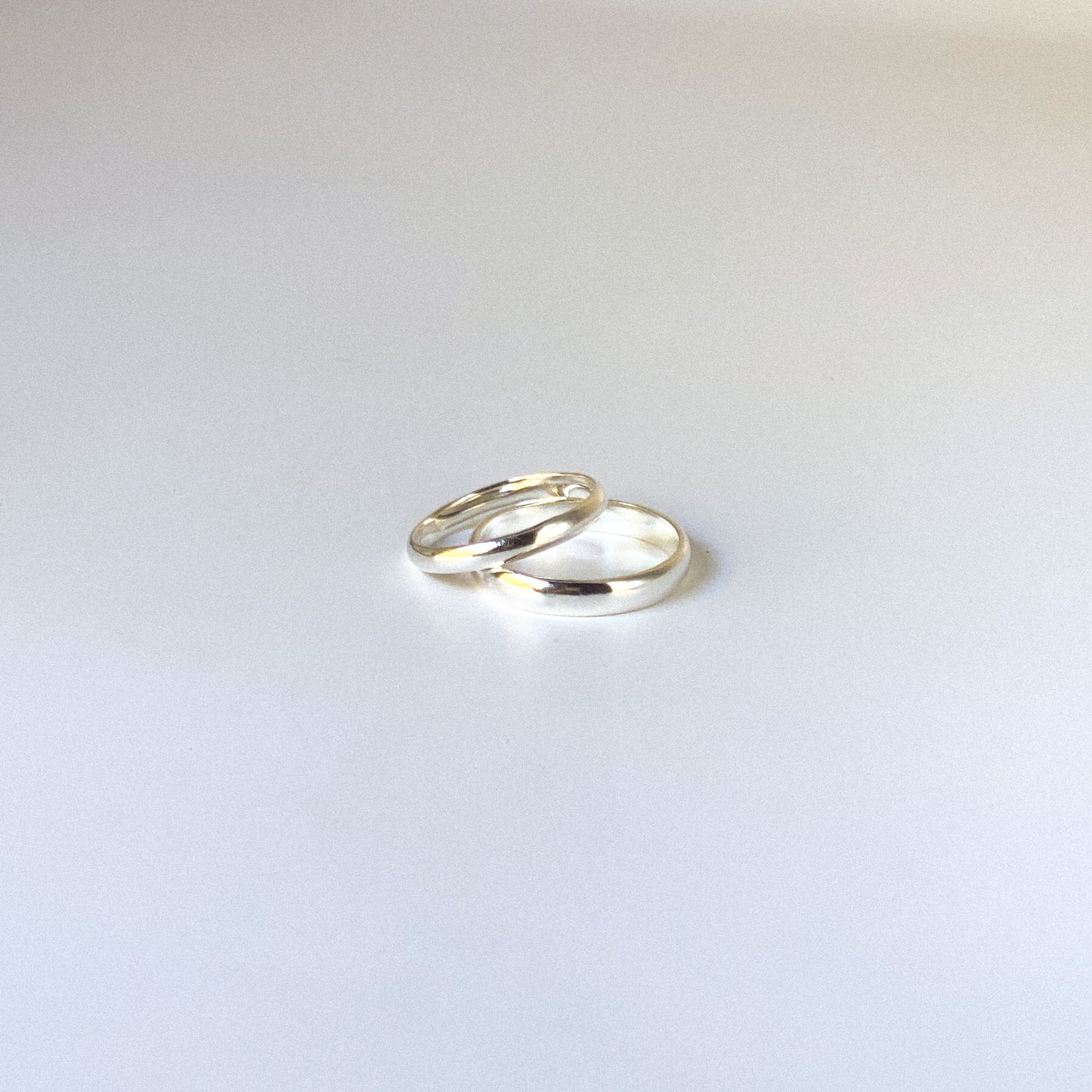 Two silver rings on a light gray background