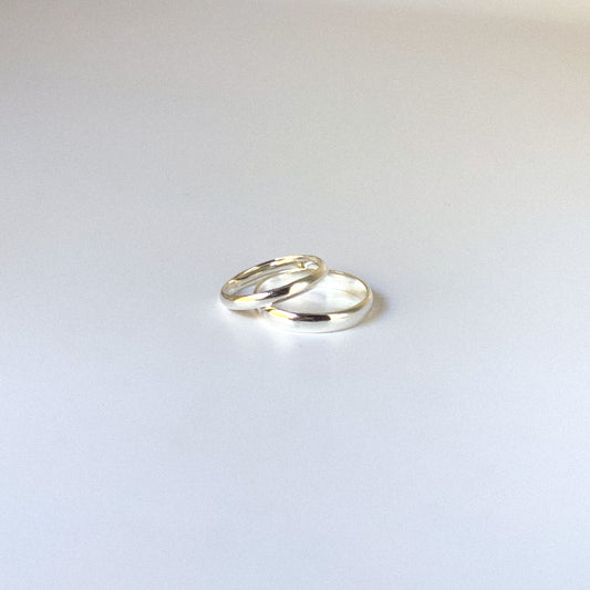 Two silver rings on a light gray background