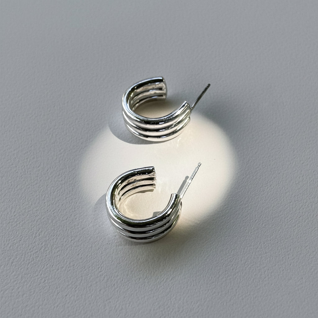 Silver hoop earrings on a light gray background