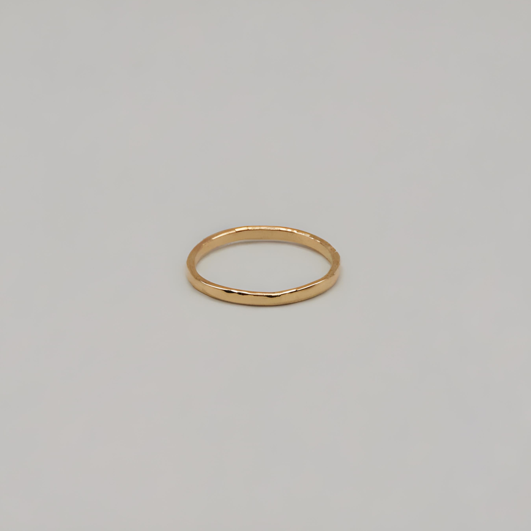 Gold textured ring on a light gray background