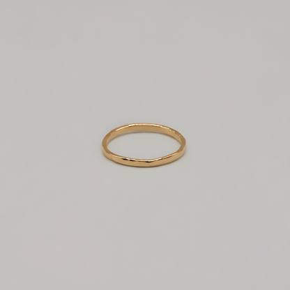 Gold textured ring on a light gray background