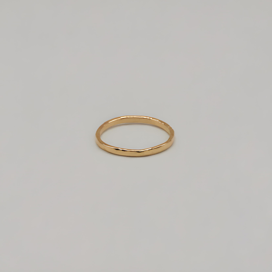 Gold textured ring on a light gray background