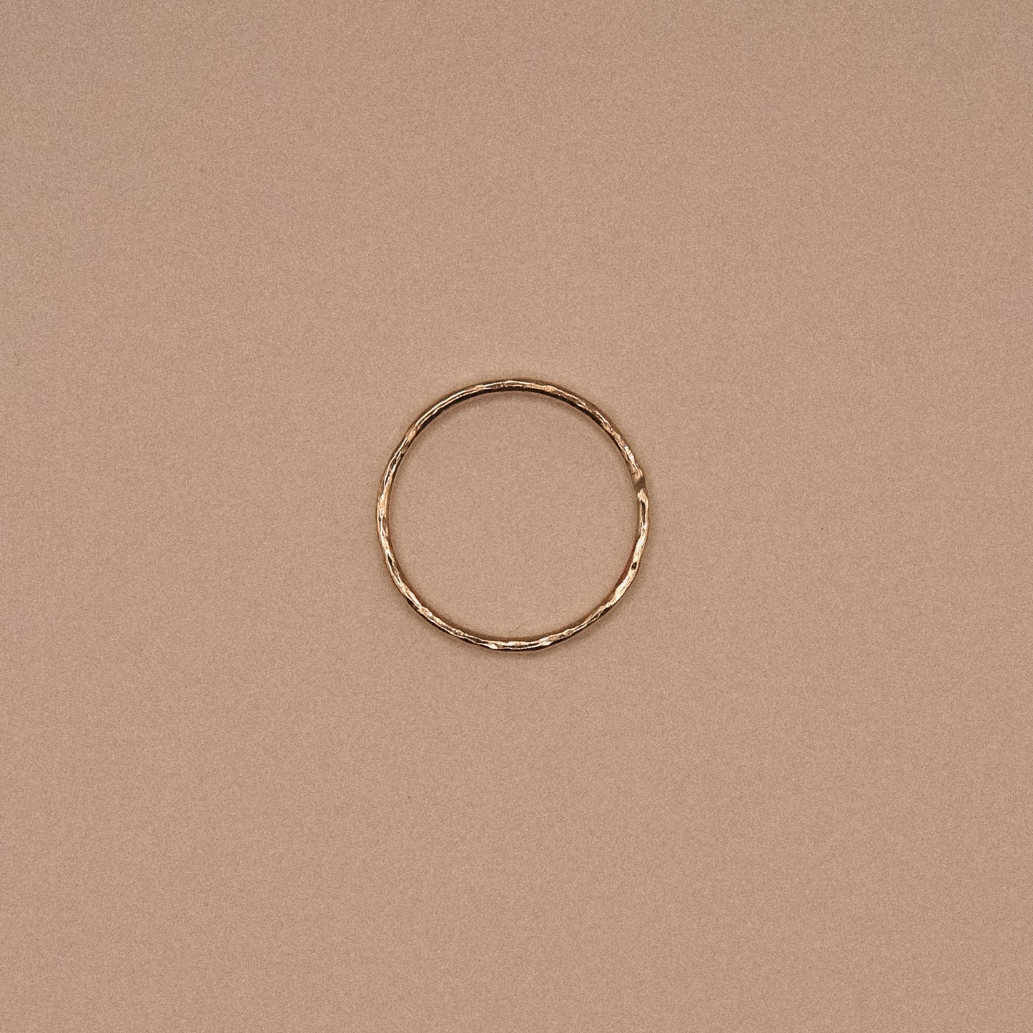 Gold ring on a beige background