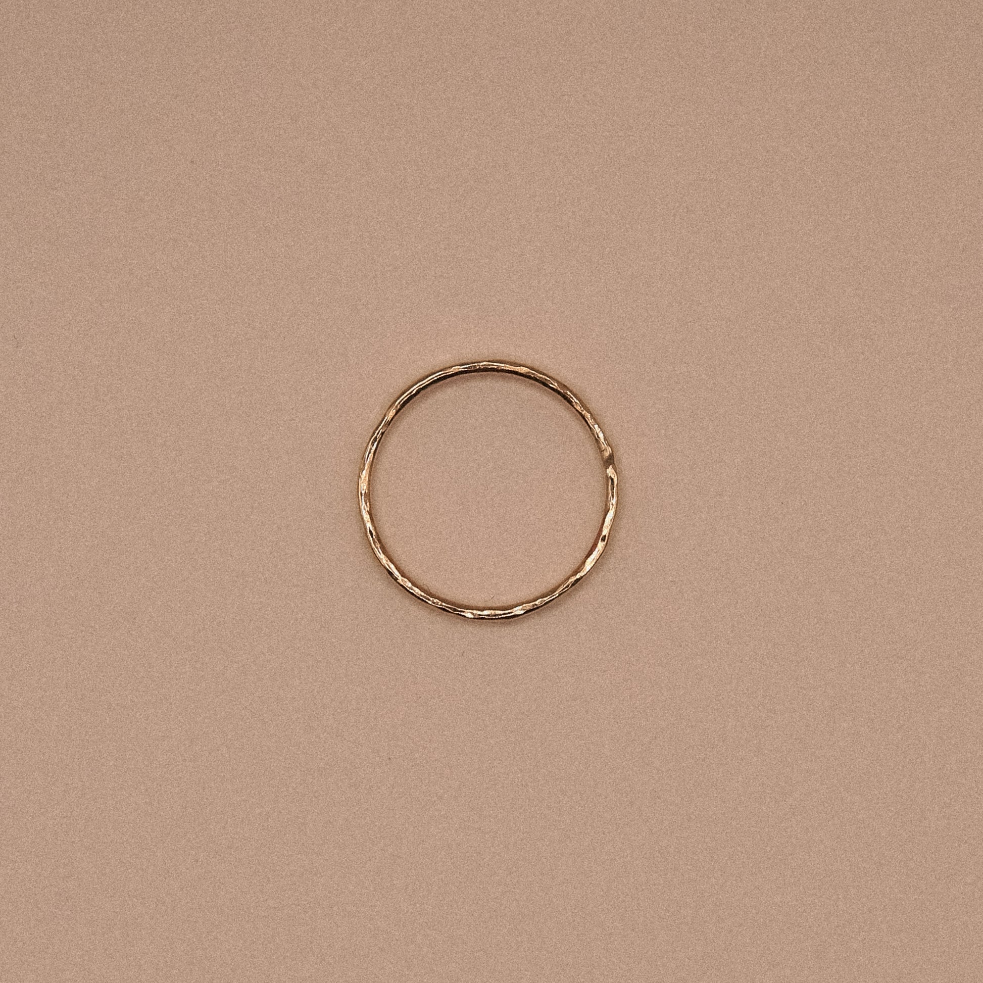 Gold ring on a beige background