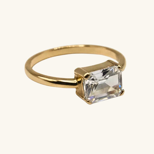 Gold ring with a clear gemstone on a white background