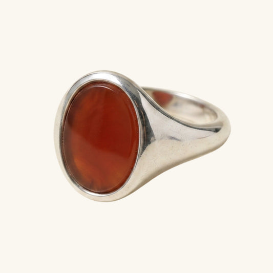 Silver ring with a red stone on a white background