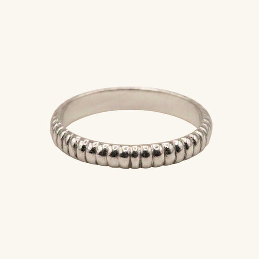 Silver ring with textured band on a white background