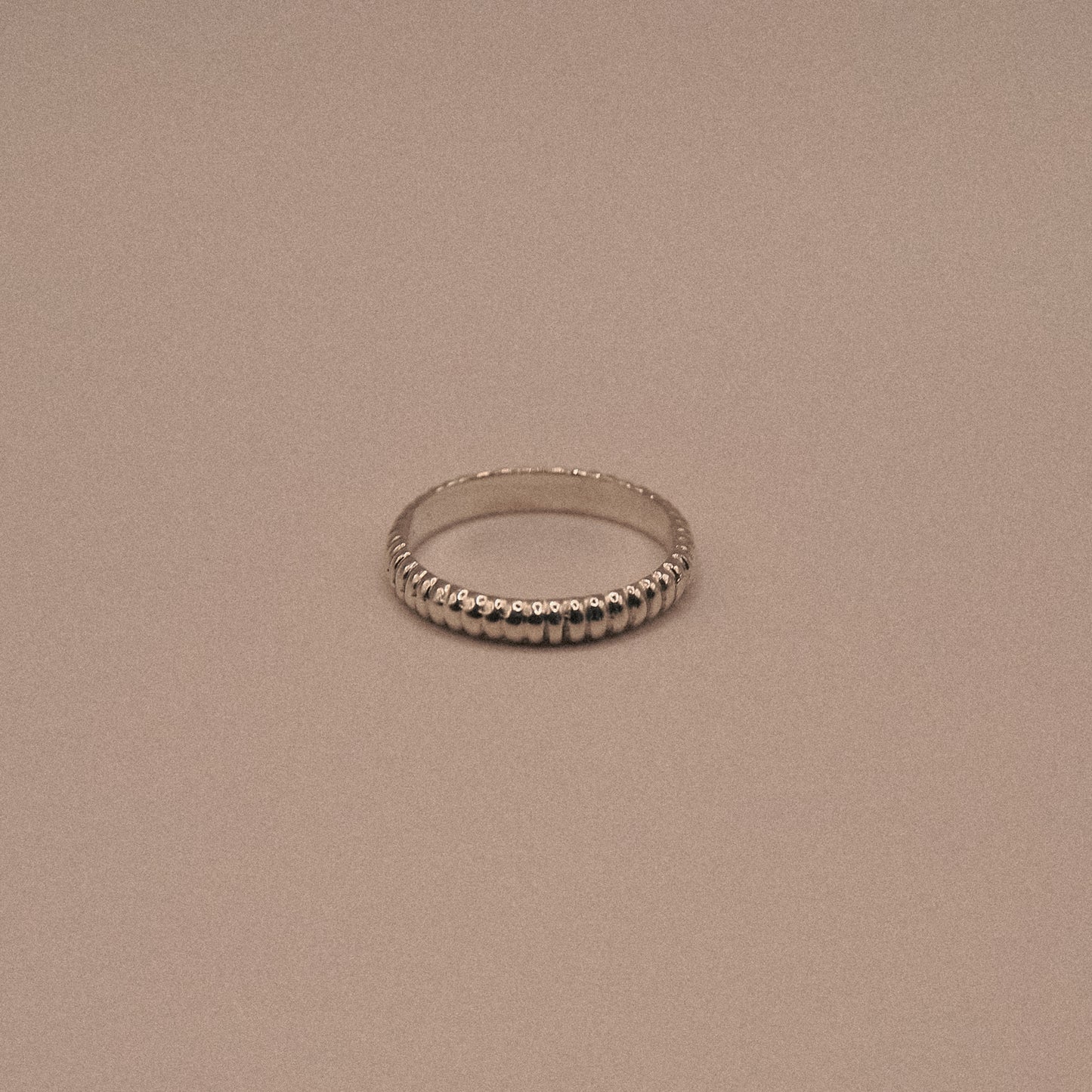 Silver ring on a beige background