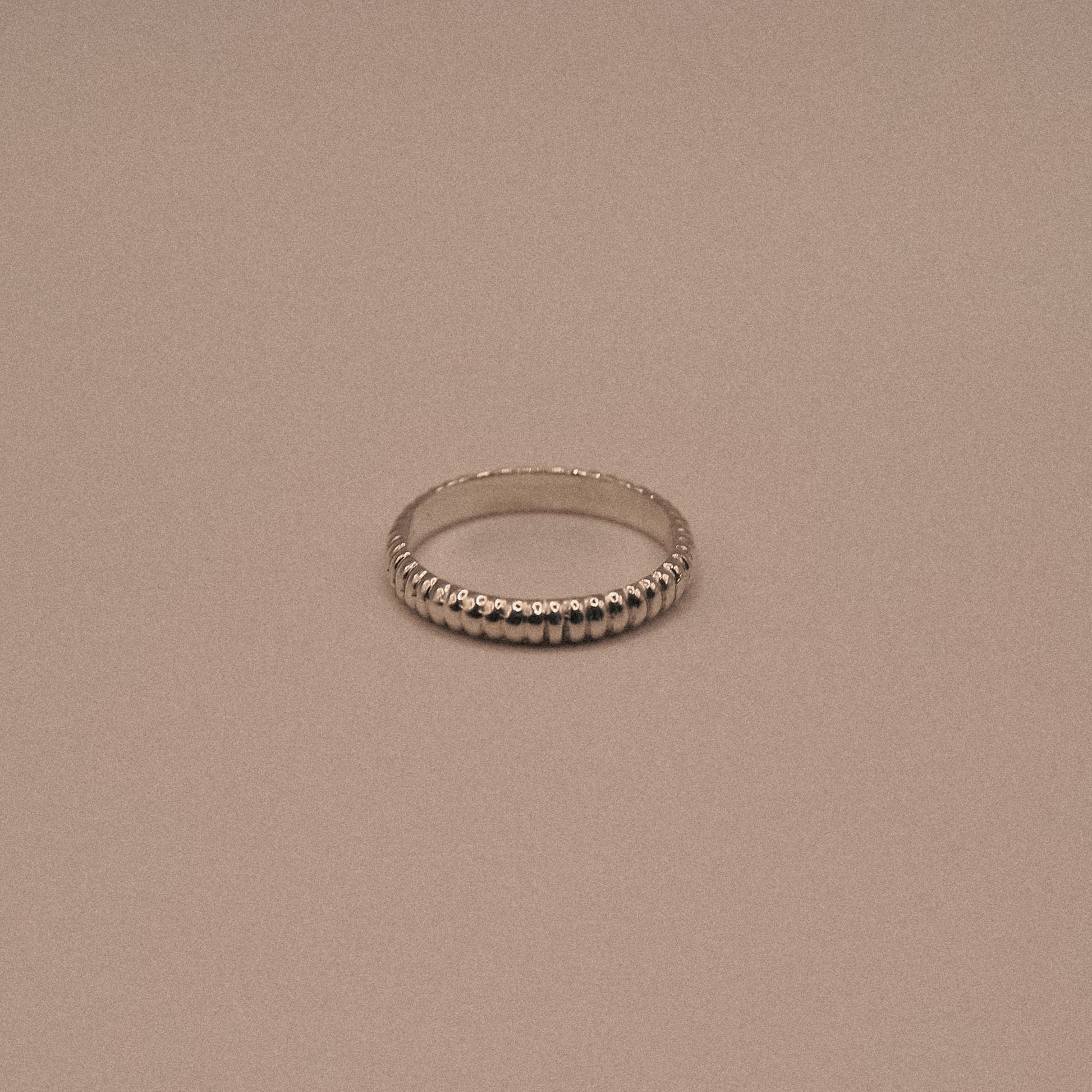 Silver ring on a beige background