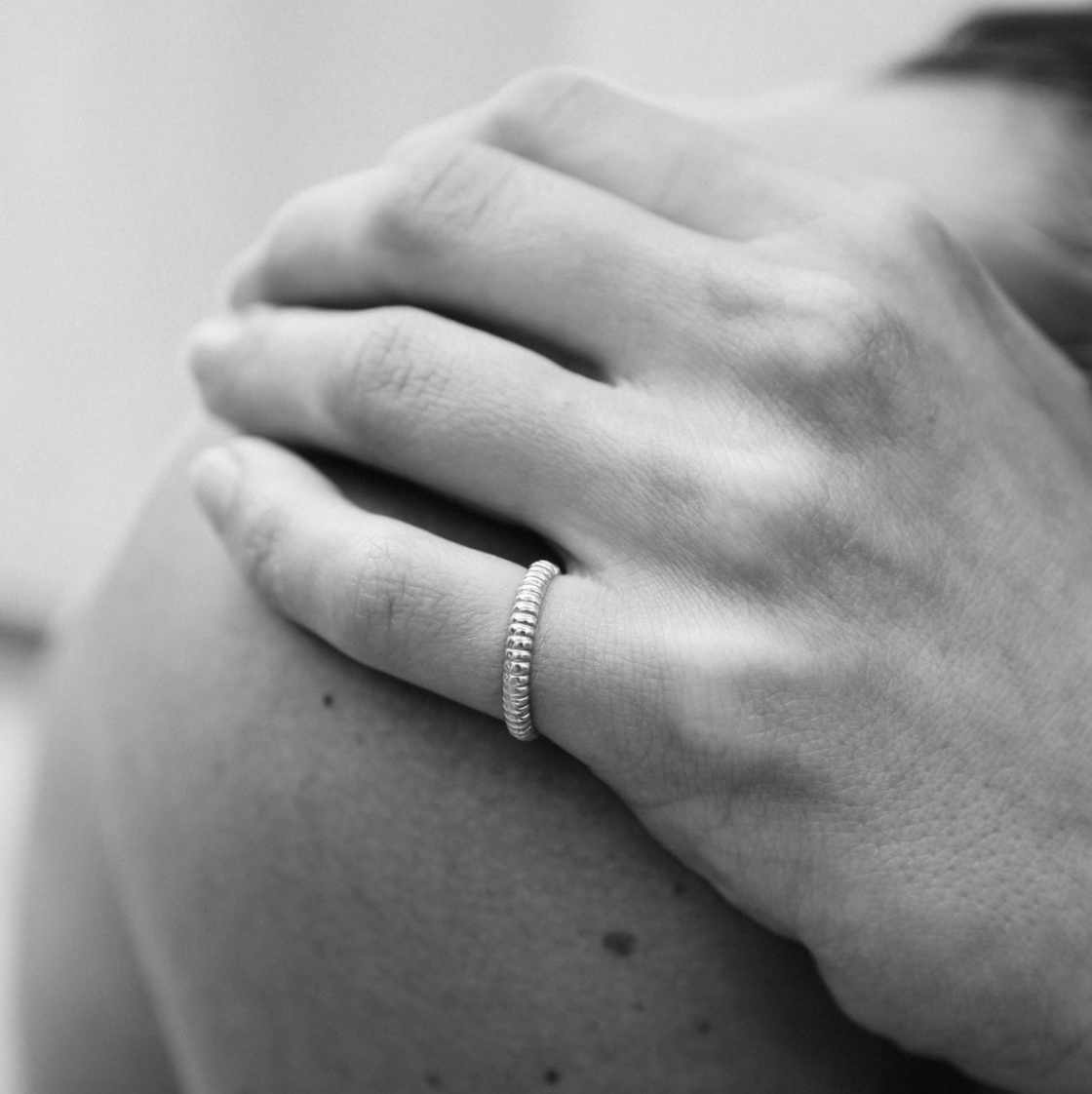 silver ring on hand on models shoulder