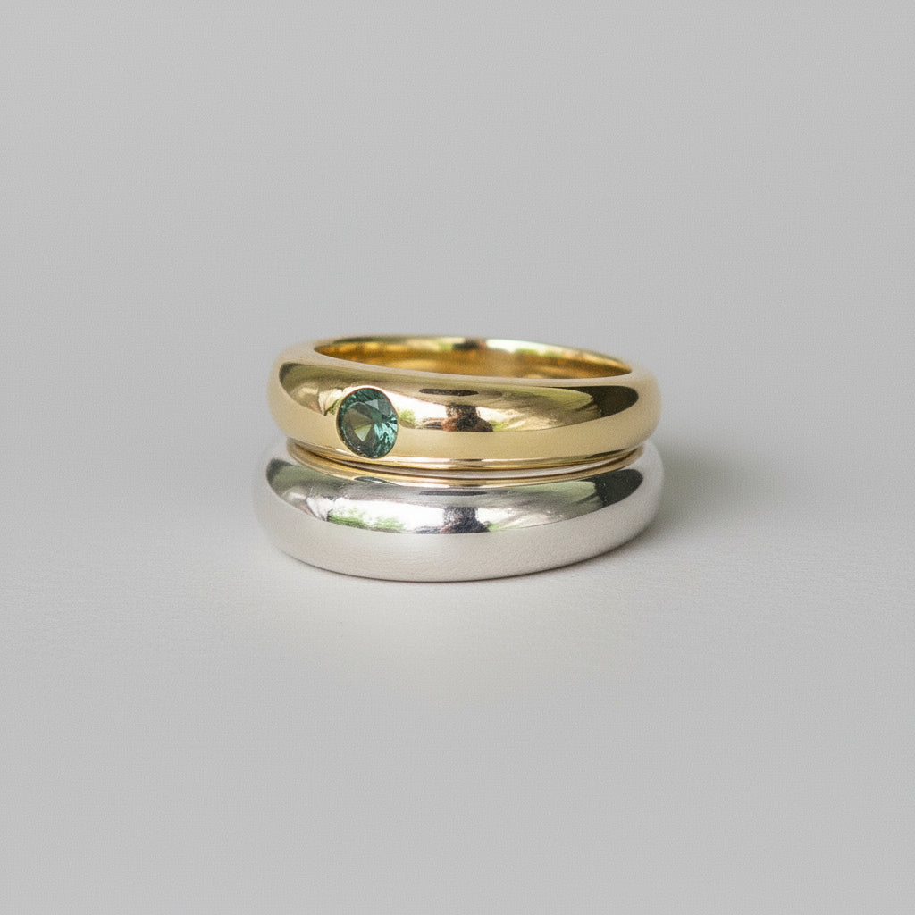 Two rings, one gold and one silver, on a whitebackground