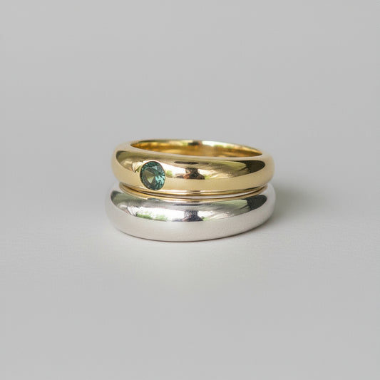 Two rings, one gold and one silver, on a whitebackground