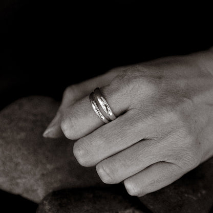 Close-up of a hand wearing a ring on a dark background