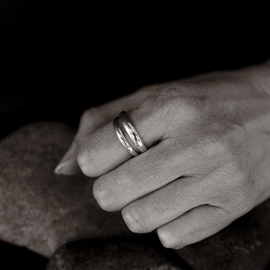 Close-up of a hand wearing a ring on a dark background