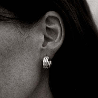 Close-up of a person wearing a silver hoop earring.
