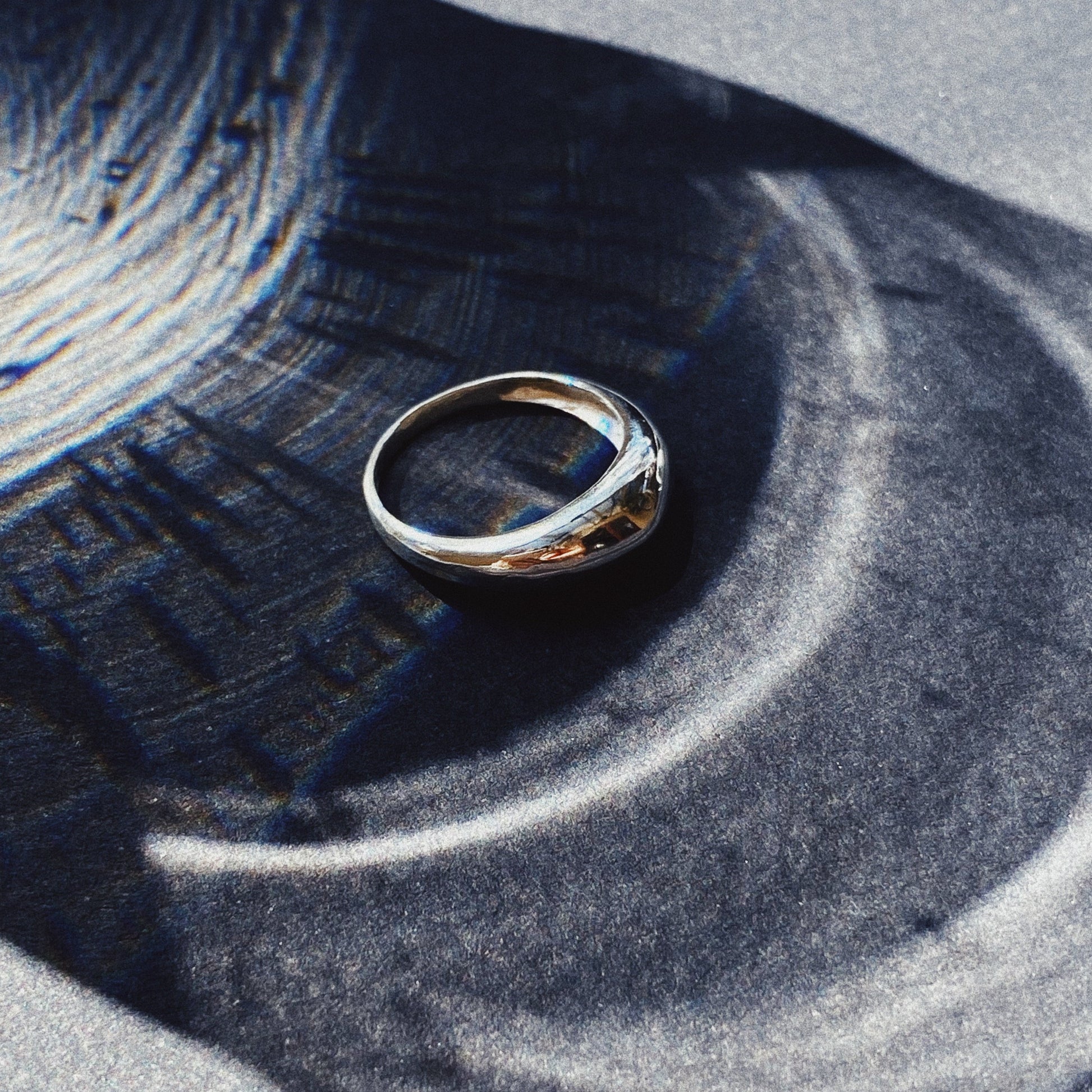 image of a silver ring on a shadowy background