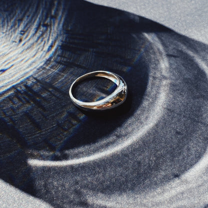 image of a silver ring on a shadowy background