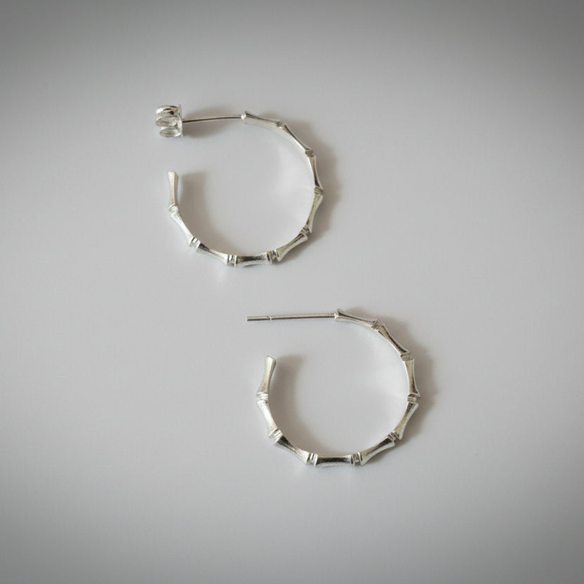 silver hoops with bamboo detail on a light grey studio backdrop