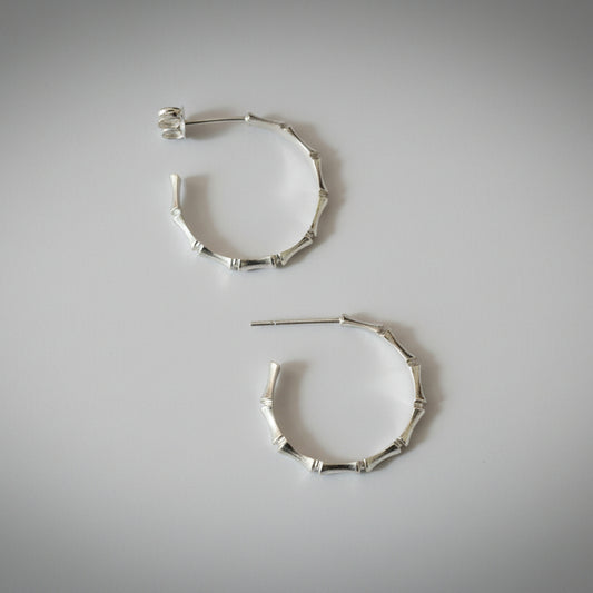 silver hoops with bamboo detail on a light grey studio backdrop